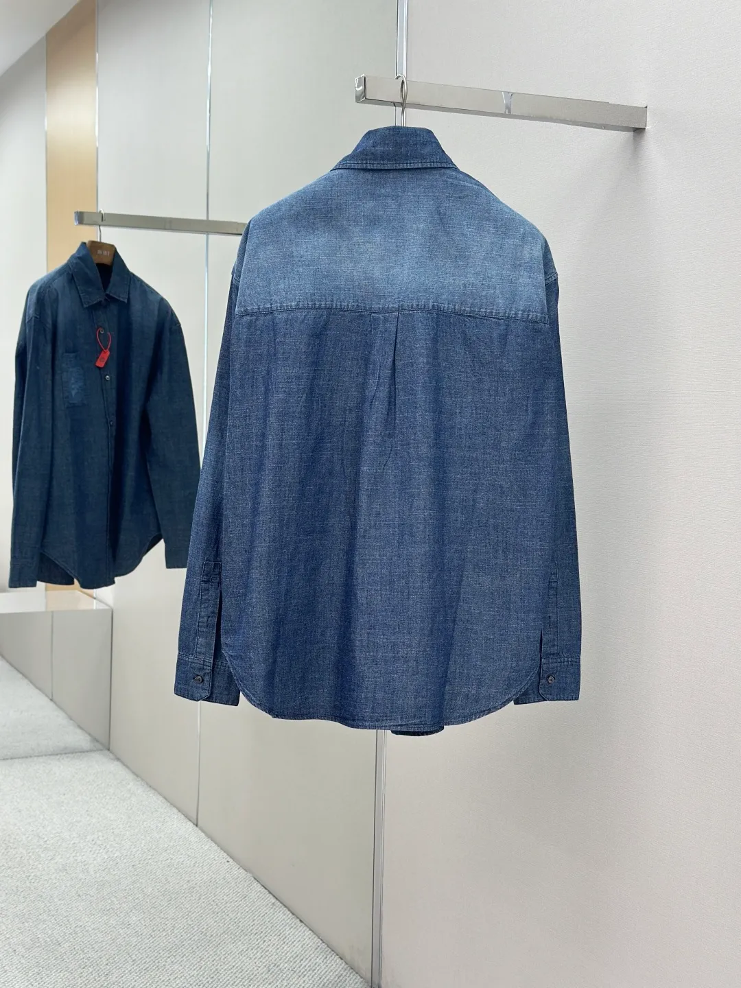 P430 Loewe Anagram Gradient Embroidered Pocket Shirt Made of custom-made high-quality cotton chambray fabric, with a unique washed gradient blue as the main tone, from dark to light and from thick to light. The chest patch pocket is decorated with Loewe Anagram embroidery as its soul, engraved with LOEWE-style casual elegance, and the natural and smooth lines show the casualness.  Imported embroidery machines are used, and advanced computer control systems and precision mechanical components are used to realize Loewe embroidery operations.  The gradient dynamic spray dyeing process uses specialized spray dyeing equipment to accurately spray dye onto the surface of the fabric in the form of mist (by accurately controlling the different dimensions of the spray of the spray dyeing equipment, combined with the movement speed and direction during the dyeing process) to present a smooth and natural transition effect of color. The butterfly rhyme pinch pleating body dart technology is inspired by the beautiful shape of butterflies, and uses precise pinch pleating techniques to create a flexible pleat effect like butterfly wings on the garment, making the garment fit more closely to the body.  size:44.46.48.50